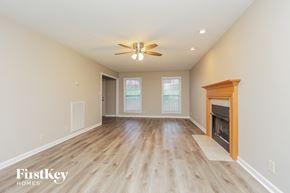 Clarksville house for rent - A spacious room with a fireplace and a ceiling fan.
