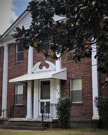Memphis apartment for rent - a brick house with a white porch and a tree