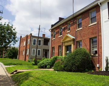 Washington apartment for rent - A row of houses with green bushes in front.
