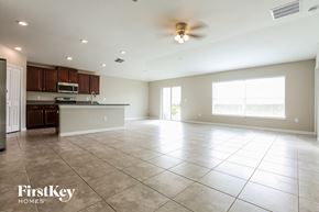 Wimauma house for rent - an empty kitchen and living room with a ceiling fan