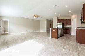 Wimauma house for rent - a kitchen and living room with tile flooring and wooden cabinets