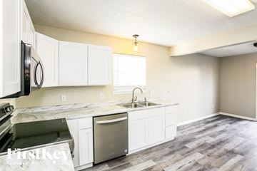 Noblesville house for rent - A kitchen with white cabinets and a marble countertop.