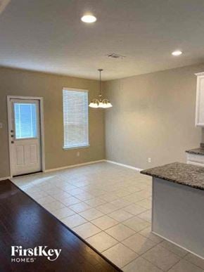Forney house for rent - A spacious kitchen and living room area with a white door and window.