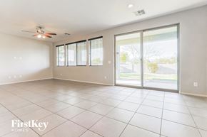 Queen Creek house for rent - an empty living room with sliding glass doors to a patio