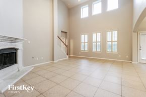 Kingwood house for rent - A spacious living room with a fireplace and a staircase.