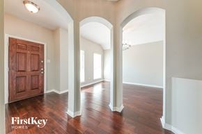 Mesquite house for rent - A room with a wooden door and arched columns.