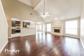 Mesquite house for rent - A spacious living room with wood flooring and a fireplace.