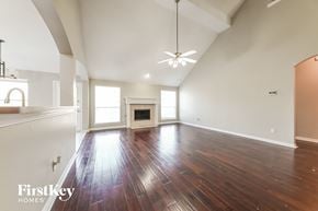 Mesquite house for rent - A spacious room with wooden floors and a fireplace.
