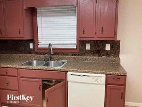 Atlanta house for rent - a kitchen with red cabinets and a sink