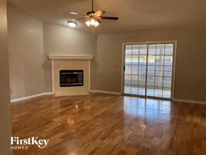 Jacksonville house for rent - an empty living room with a fireplace and a ceiling fan
