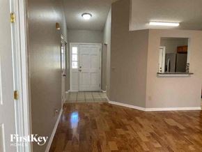 Jacksonville house for rent - a living room with a wooden floor and a white door