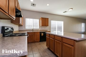 Avondale house for rent - A kitchen with brown cabinets and a black stove top oven.