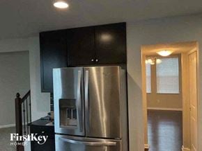 Columbus house for rent - a kitchen with a stainless steel refrigerator and black cabinets