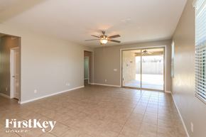 Tolleson house for rent - A spacious room with a ceiling fan and sliding glass doors leading to a balcony.