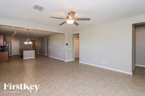 Tolleson house for rent - A spacious room with a ceiling fan and lighting fixtures.