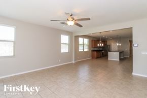 Tolleson house for rent - A spacious living room with a ceiling fan and tiled flooring.
