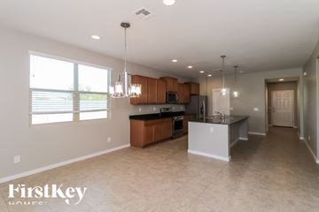 Tolleson house for rent - A spacious kitchen with wooden cabinets and a black countertop.