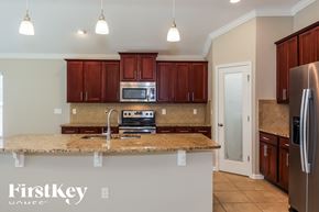 Jacksonville house for rent - a kitchen with granite counter tops and wooden cabinets