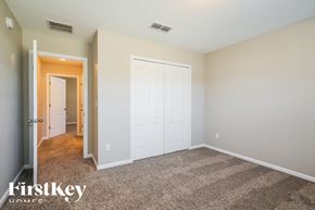 Jacksonville house for rent - a bedroom with white doors and carpeting and a door to a hallway