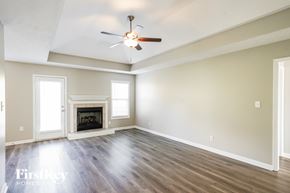 Pleasant View house for rent - A spacious room with a fireplace and a ceiling fan.
