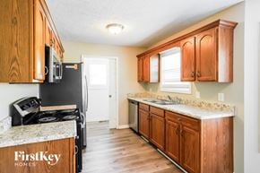 Pleasant View house for rent - A kitchen with wooden cabinets and a granite countertop.