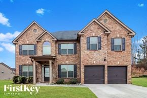 Covington house for rent - a large brick house with two garage doors