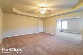 Covington house for rent - the spacious living room with carpeting and a ceiling fan