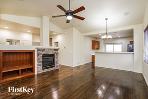 Peyton house for rent - an empty living room with a fireplace and a ceiling fan