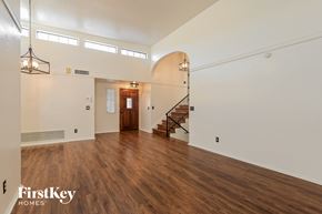 Oro Valley house for rent - A spacious room with wooden floors and a staircase.