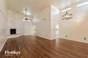 Oro Valley house for rent - A spacious living room with wood flooring and a fireplace.
