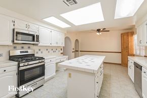 Oro Valley house for rent - A kitchen with white cabinets and appliances.