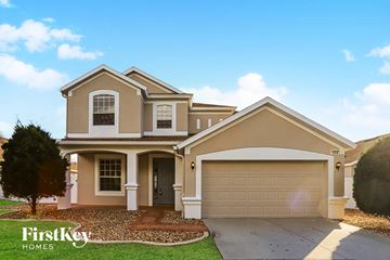 Valrico house for rent - a beige house with a garage and a driveway