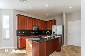 Valrico house for rent - a kitchen with granite counter tops and wooden cabinets