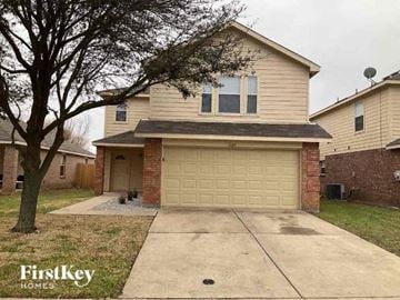 Fort Worth house for rent - a yellow house with a driveway and a garage door