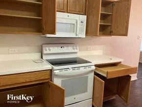 Fort Worth house for rent - a kitchen with a white stove and a microwave