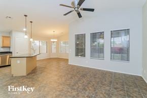 Phoenix house for rent - an empty living room and kitchen with a ceiling fan
