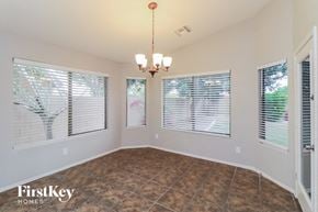 Phoenix house for rent - an empty dining room with three windows and a chandelier
