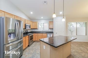 Phoenix house for rent - a large kitchen with stainless steel appliances and granite counter tops