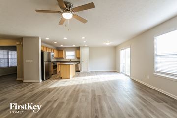 Indianapolis house for rent - A spacious living room with a ceiling fan and lighting fixtures.