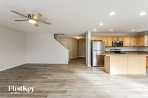 Indianapolis house for rent - A spacious kitchen and living room with a wood floor and a ceiling fan.