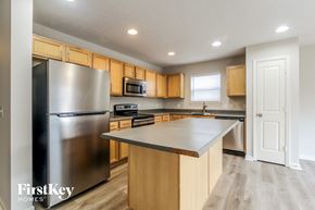 Indianapolis house for rent - A kitchen with wooden cabinets and a stainless steel refrigerator.