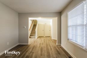 Indianapolis house for rent - A hallway with wooden floors and a staircase leading to another room.