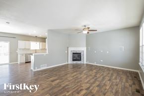 Commerce City house for rent - A spacious living room with a fireplace and a ceiling fan.