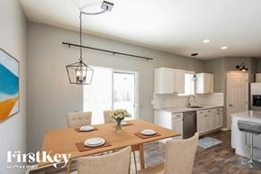 Commerce City house for rent - A dining room with a wooden table set for four.