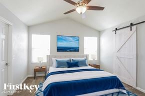 Commerce City house for rent - A bedroom with a bed, a ceiling fan, and a painting on the wall.