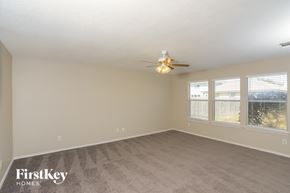 San Antonio house for rent - an empty living room with a ceiling fan and windows