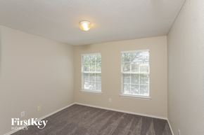 San Antonio house for rent - a bedroom with a carpeted floor and two windows