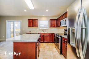 Commercial Point house for rent - a kitchen with wooden cabinets and stainless steel appliances and a marble counter top