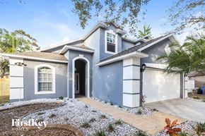 Valrico house for rent - a blue house with a driveway and a garage door