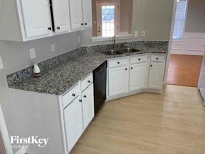 Lawrenceville house for rent - A kitchen with granite countertops and white cabinets.